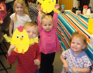Children showing off their baby chick craft.