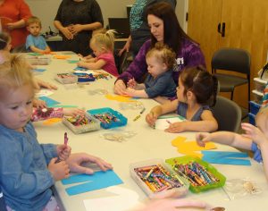 Children and parents coloring during craft time.