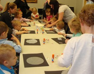 Children and parents making a moon craft.