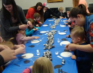 Children and parents making a sheep craft.